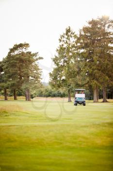 Front View Of Couple Playing Golf Driving Buggy Along Fairway On Red Letter Day