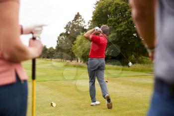 Golf Professional Demonstrating Tee Shot To Group Of Golfers During Lesson