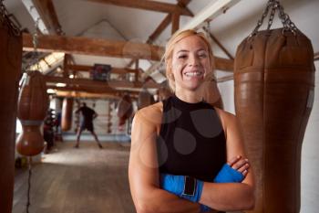 Portrait Of Smiling Female Boxer With Protective Wraps On Hands Training In Gym