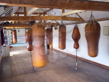 Empty Boxing Training Gym With Old Fashioned Leather Punch Bags