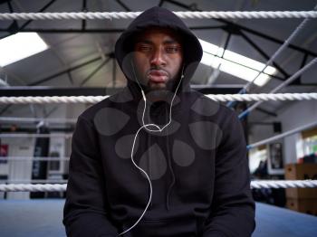 Portrait Of Male Boxer Training In Gym Listening To Music On Headphones In Boxing Ring
