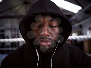 Male Boxer With Eyes Closed Training In Gym Listening To Music On Headphones In Boxing Ring
