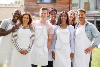 Group Portrait Of Men And Women Attending Cookery Class Relaxing Outdoors