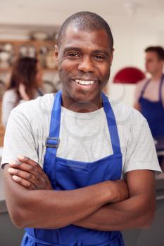 Portrait Of Smiling Man Wearing Apron Taking Part In Cookery Class In Kitchen