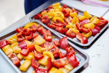 Close Up Of Trays Of Chopped Peppers Ready For Oven  In Kitchen Cookery Class