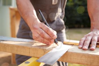 Close Up Male Carpenter Measuring Wood Using Set Square Outdoors