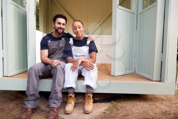 Portrait Of Couple Taking A Break From Building Outdoor Summerhouse In Garden