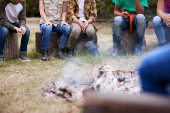 Close Up Of Children On Outdoor Activity Camping Trip Sit Around Camp Fire Together