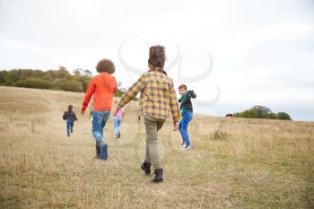 Rear View Of Group Of Children On Outdoor Activity Camping Trip Walking Up Hill