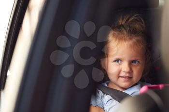 Young Girl Watching Digital Tablet In Back Seat On Car Journey