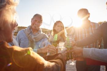 Multi-Generation Adult Family Making A Toast With Alcohol On Winter Beach Vacation