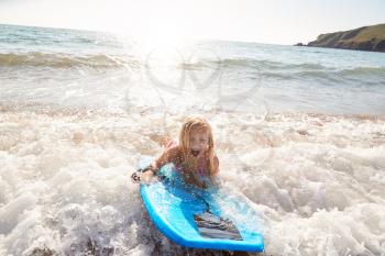 Girl Playing In Sea With Bodyboard On Summer Beach Vacation