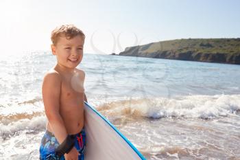 Boy Playing In Sea With Bodyboard On Summer Beach Vacation