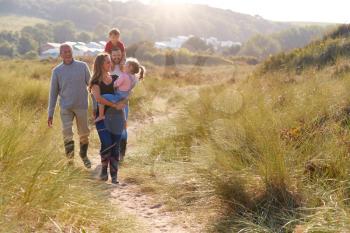 Multi-Generation Family Walking Along Path Through Sand Dunes Together