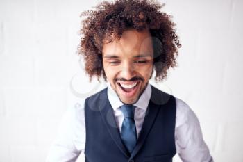 Happy Young Businessman Wearing Suit Celebrating Standing Against White Studio Wall