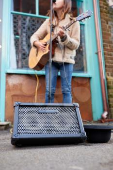 Close Up Of Female Musician Busking Playing Acoustic Guitar Outdoors In Street
