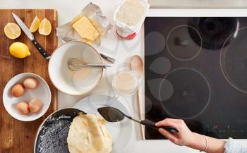 Overhead Shot Of Woman In Kitchen Serving Pancakes Or Crepes For Pancake Day