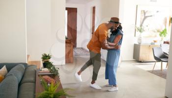 Loving African American Couple Hugging And Dancing  In Hall At Home