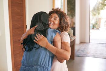 Loving Senior Mother Hugging Adult Daughter Indoors At Home