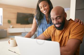 African American Couple Using Laptop To Check Finances At Home