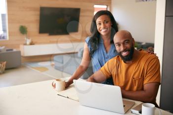 Portrait Of African American Couple Using Laptop To Check Finances At Home