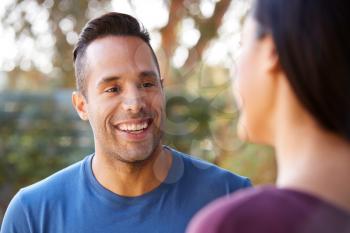 Smiling Hispanic Couple Talking And Laughing In Garden At Home