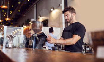 Male Coffee Shop Owner Working Behind Sales Desk