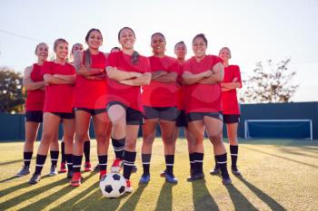 Portrait Of Smiling Womens Football Team Training For Soccer Match On Outdoor Astro Turf Pitch
