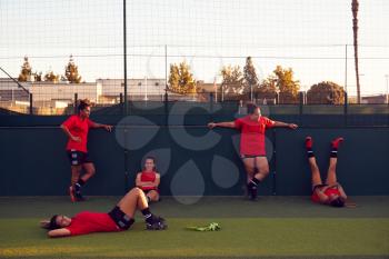 Portrait Of Womens Football Team Relaxing After Training For Soccer Match On Outdoor Pitch