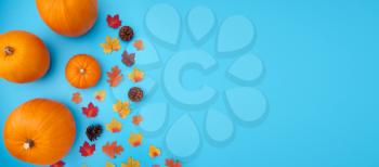 Overhead Flat Lay Autumn Banner Composed Of Pumpkins With Leaves And Pine Cones On Blue Background