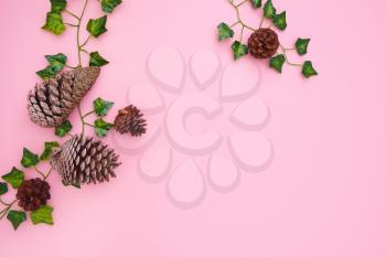 Overhead Flat Lay Autumn Banner Composed Of Ivy Leaves And Pine Cones On Pink Background