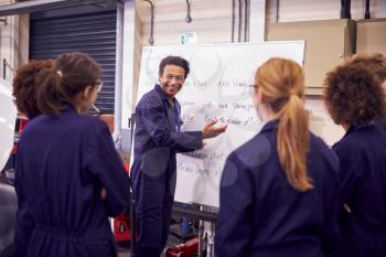 Male Tutor By Whiteboard With Students Teaching Auto Mechanic Apprenticeship At College