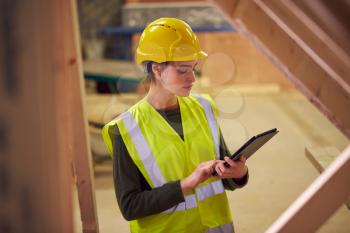 Female Safety Inspector With Digital Tablet At Construction Site