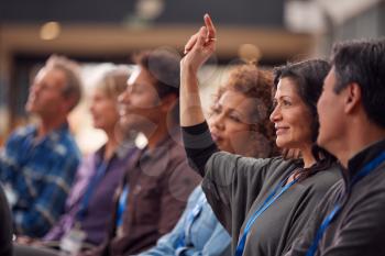 Businesswoman In Presentation At Conference Raising Hand To Ask Question