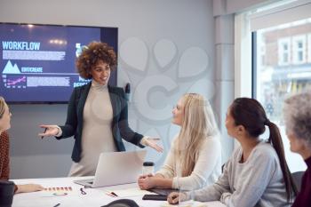 Pregnant  Businesswoman Leads Creative Meeting Of Women Collaborating Around Table In Modern Office