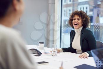 Smiling African American Businesswoman Sitting At Table In Office  Meeting Room