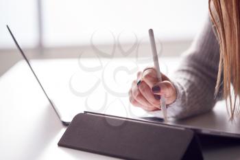 Close Up Of Businesswoman Working From Home Drawing On Digital Tablet Using Stylus Pen