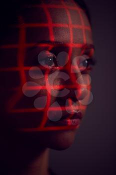 Facial Recognition Technology Concept As Woman Has Red Grid Projected Onto Face In Studio