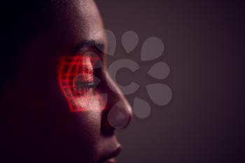 Facial Recognition Technology Concept As Woman Has Red Grid Projected Onto Eye In Studio