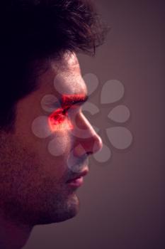 Facial Recognition Technology Concept As Man Has Red Grid Projected Onto Eye In Studio