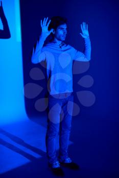Studio Shot Of Man With Body Illuminated By Blue Light