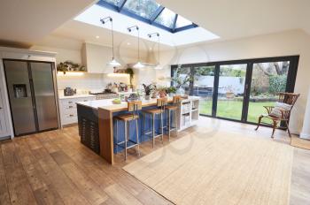 Interior View Of Beautiful Kitchen With Island Counter And Table For Children In New Family House