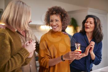 Group Of Mature Friends Meeting At Home To Celebrate Womans Birthday With Cake