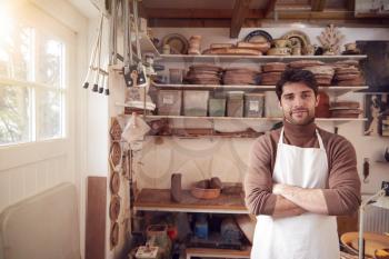 Portrait Of Male Potter Wearing Apron In Ceramics Studio