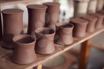 Clay Pots On Shelf Waiting For Decoration In Ceramics Studio