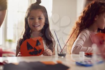 Portrait Of Daughter At Home With Father Having Fun Making Halloween Decoration Together