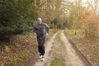 Smiling Senior Man Running In Autumn Countryside Exercising During Covid 19 Lockdown