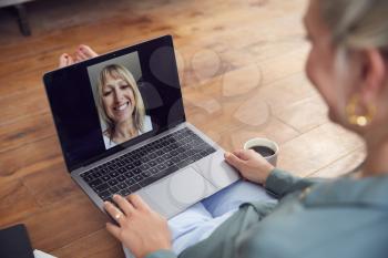 Woman With Laptop Having Video Chat With Friend Sitting On Floor At Home Relaxing