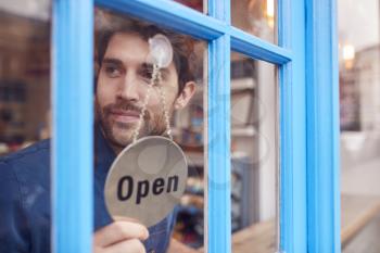 Small Business Owner Turning Around Open Sign On Shop Or Store Door