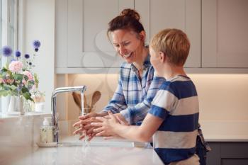 Mother And Son Washing Hands With Soap At Home To Stop Spread Of Infection In Health Pandemic